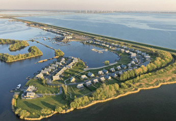 Vue aérienne de la Villa Oesterdam à Oesterdam Resort, Pays-Bas, avec de petites maisons près de l’eau.