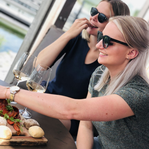 Dos mujeres disfrutan vino y pan en una mesa en Villa Oesterdam del Oesterdam Resort, Países Bajos.