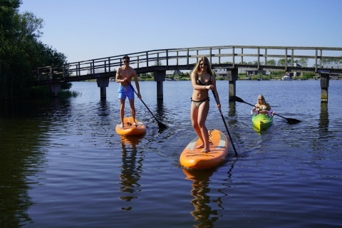 Menschen genießen Stand-Up-Paddling und Kajakfahren an der Villa Oesterdam, Oesterdam Resort, Niederlande.