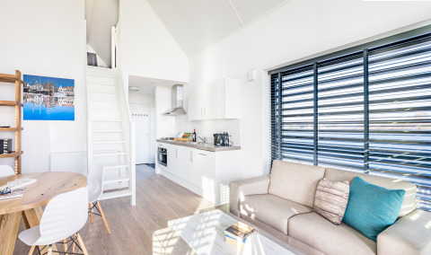 Helles, modernes Wohnzimmer im Villa Oesterdam Tiny House im Oesterdam Resort, Niederlande, mit Küche.