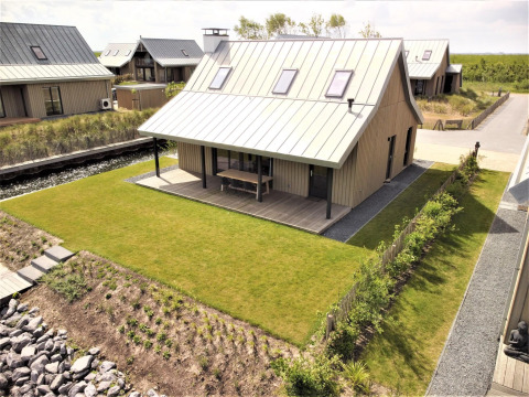 Ferienhaus Villa Oesterdam Comfort Extra im Oesterdam Resort in den Niederlanden mit moderner Holzfassade.