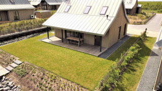 Lodge Villa Oesterdam Comfort Extra bij Oesterdam Resort in Nederland, modern huis met tuin en veranda.