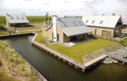 Moderne villa’s met gazon en waterkanalen op Oesterdam Resort in Nederland, luchtfoto overdag.