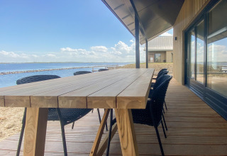 Terrasse der Villa Oesterdam Comfort Extra mit Holztisch und Wasserblick im Oesterdam Resort, Niederlande.