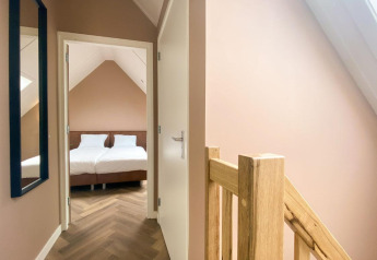 Helles Schlafzimmer und Flur in der Villa Oesterdam Comfort Extra im Oesterdam Resort, Niederlande.