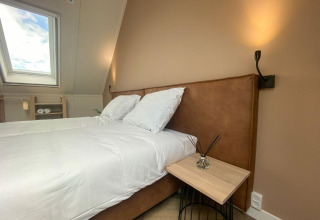 Dormitorio moderno con ropa de cama blanca en Villa Oesterdam Comfort Extra, Oesterdam Resort, Países Bajos.