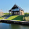 Moderne Villa Oesterdam Deluxe met schuine grasheuvel en privé water toegang in Oesterdam Resort, Nederland.