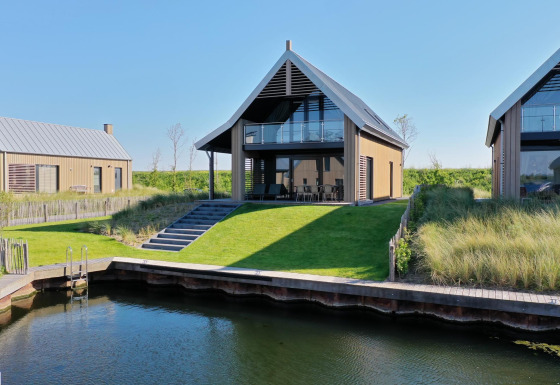 Moderne Villa Oesterdam Deluxe mit privatem Wasserzugang und grüner Wiese im Oesterdam Resort, Niederlande.