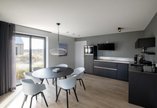 Modernes Wohnzimmer und Küche in der Villa Oesterdam Deluxe, Oesterdam Resort, Niederlande, mit viel Licht.