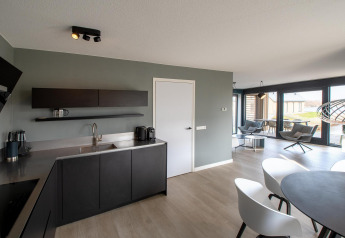 Moderne køkken- og opholdsområde i Villa Oesterdam Deluxe, Oesterdam Resort, Holland, med elegant indretning.