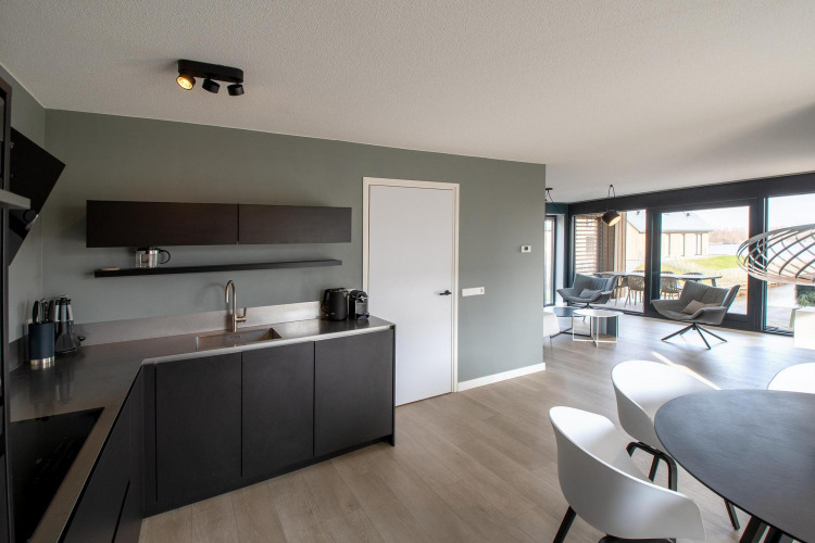 Moderne keuken en woonkamer in Villa Oesterdam Deluxe, Oesterdam Resort, Nederland, met stijlvolle inrichting.