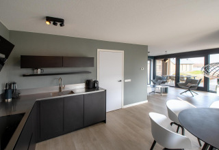 Modernes Küchen- und Wohnzimmer in der Villa Oesterdam Deluxe im Oesterdam Resort, Niederlande, stilvoll eingerichtet.