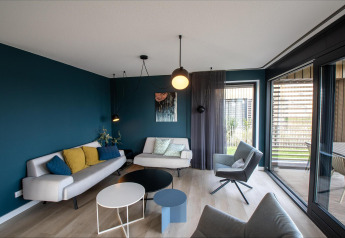 Moderne stue i Villa Oesterdam Deluxe på Oesterdam Resort, Holland, med stilfuld indretning og store vinduer.