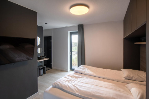 Dormitorio moderno de tiny house en Villa Oesterdam Deluxe, Oesterdam Resort Países Bajos, con dos camas individuales.