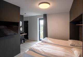 Dormitorio moderno de tiny house en Villa Oesterdam Deluxe, Oesterdam Resort Países Bajos, con dos camas individuales.