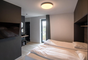 Moderne tiny house soveværelse i Villa Oesterdam Deluxe ved Oesterdam Resort, med to enkeltsenge og tv.