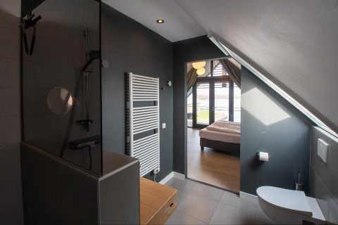 Baño y dormitorio modernos en una tiny house de Villa Oesterdam Deluxe, Oesterdam Resort, Países Bajos.