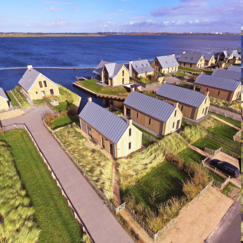 Luchtfoto van Villa Oesterdam in Oesterdam Resort, Nederland, met moderne lodges aan het water.