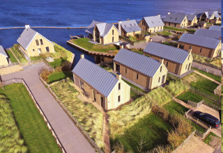 Vista aérea de Villa Oesterdam en Oesterdam Resort, Países Bajos, con cabañas modernas junto al agua.