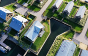 Luchtfoto van moderne lodges met metalen daken en waterwegen in Villa Oesterdam, Oesterdam Resort, Nederland.