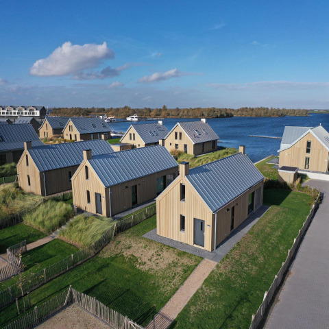 Vista aérea de modernas cabañas de madera junto al agua en Villa Oesterdam Resort, Oesterdam, Países Bajos.