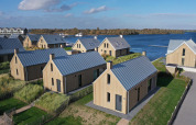 Luchtfoto van moderne houten villa’s aan het water bij Villa Oesterdam Resort, Oesterdam, Nederland.