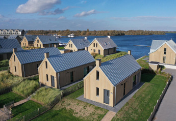 Vue aérienne de chalets en bois modernes au bord de l’eau à Villa Oesterdam Resort, Oesterdam, Pays-Bas.