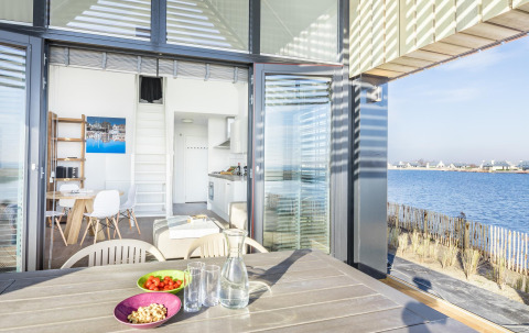 Moderne lodge Villa Oesterdam met terras en prachtig uitzicht op het water bij Oesterdam Resort Nederland.