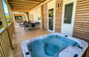 Véranda en bois avec jacuzzi et espace repas au Cottage Hot tub, Ossiacher See, Autriche, vue nature.