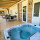 Houten veranda met bubbelbad en eettafel bij Cottage Hot tub, Ossiacher See, Oostenrijk, uitzicht op natuur.