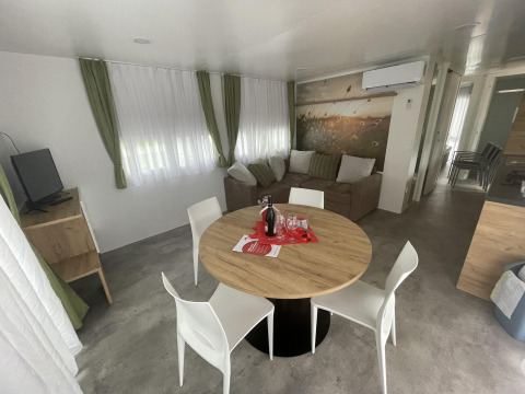Sala moderna en Cottage Hot tub en Ossiacher See, Austria, con sofá, mesa de comedor y televisión.