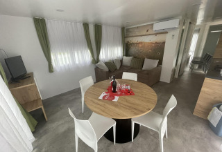 Sala moderna en Cottage Hot tub en Ossiacher See, Austria, con sofá, mesa de comedor y televisión.