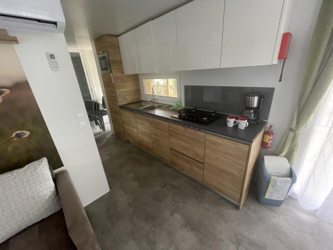 Moderne køkken i Cottage Hot tub ved Ossiacher See, Østrig, med træskabe og kaffemaskine.