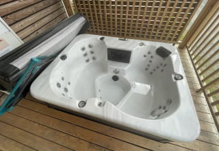 Jacuzzi exterior en terraza de madera en Cottage Hot tub en Ossiacher See, Austria, imagen de una cabaña.