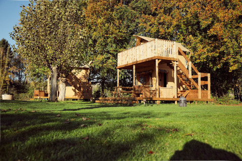 Tienda glamping Arriba, una tienda safari en Resort de Parel, Países Bajos, rodeada de árboles y césped.