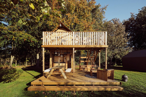 Tente safari glamping Arriba au Resort de Parel aux Pays-Bas, terrasse en bois et salon extérieur.