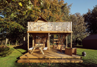 Tente safari glamping Arriba au Resort de Parel aux Pays-Bas, terrasse en bois et salon extérieur.