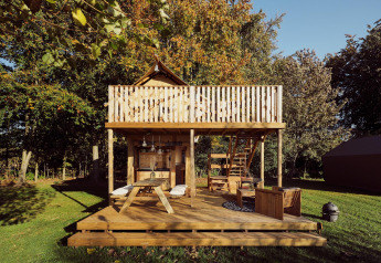 Glamping safaritent Arriba op Resort de Parel in Nederland met houten terras en gezellige buitenruimte.