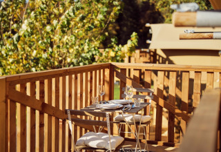 Zona pranzo all'aperto su terrazza in legno presso la tenda glamping Arriba, Resort de Parel, Paesi Bassi