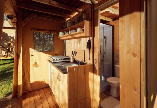 Indretning af Glamping-telt Arriba med lille køkken og badeværelse på Resort de Parel, Holland.