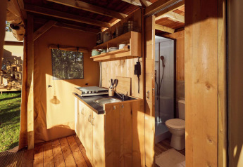 Interior de la tienda Glamping Arriba con cocina y baño en Resort de Parel, Países Bajos.