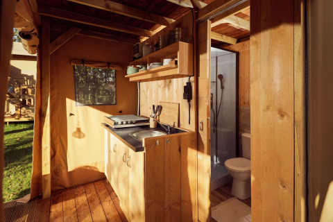 Innenansicht des Glamping-Zelts Arriba mit Küchenzeile und Bad im Resort de Parel, Niederlande.