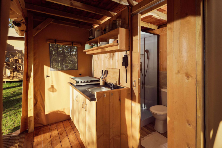 Interieur van Glamping tent Arriba met keuken en badkamer bij Resort de Parel in Nederland.