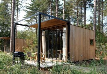 Pequeña cabaña de madera Sweet Cabin en Cosy Cabins, ubicada en el bosque de Limburg, Bélgica.