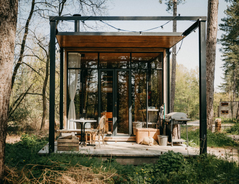 Sweet Cabin en Cosy Cabins, bosque de Limburg, Bélgica, con fachada de cristal y porche acogedor.