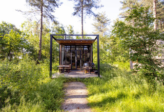 Tiny modern Sweet Cabin at Cosy Cabins in the forest of Limburg, Belgium, surrounded by greenery.