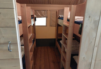 Indvendigt billede af Safari-telt med køjesenge og trægulv på Camping de Beukenhof, Holland.