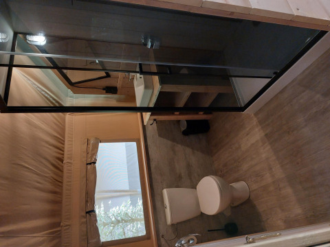 Salle de bain d’une tente safari avec sanitaires au Camping de Beukenhof aux Pays-Bas, toilettes et douche.