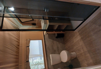 Baño en tienda safari con instalaciones en Camping de Beukenhof, Países Bajos, con inodoro y ducha.