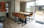 Dining area with six chairs and a large table in Family lodge at Holiday park De Boshoek, Netherlands.